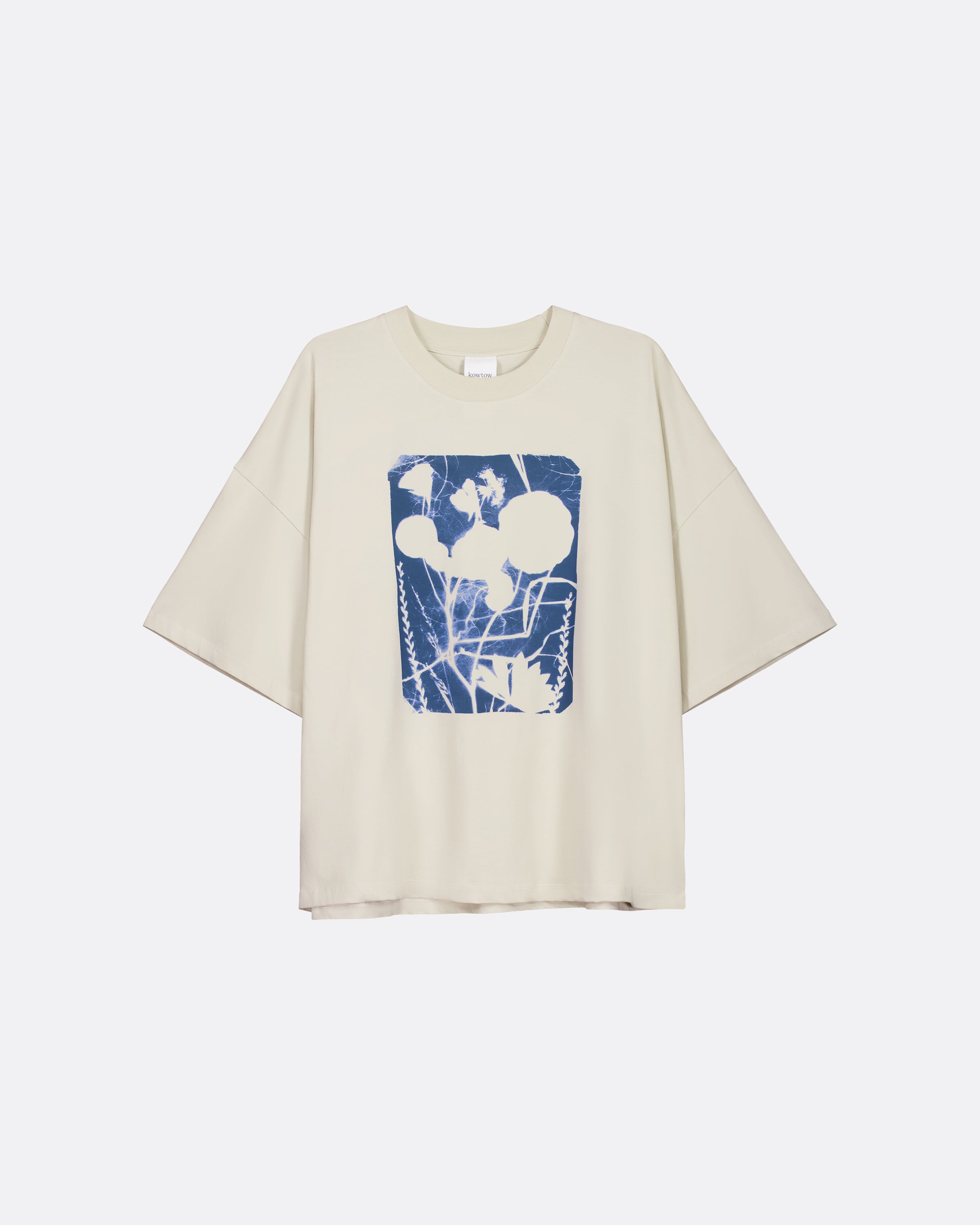A cream-colored short-sleeve t-shirt with a blue and white abstract graphic print on the front, displayed against a light gray background.