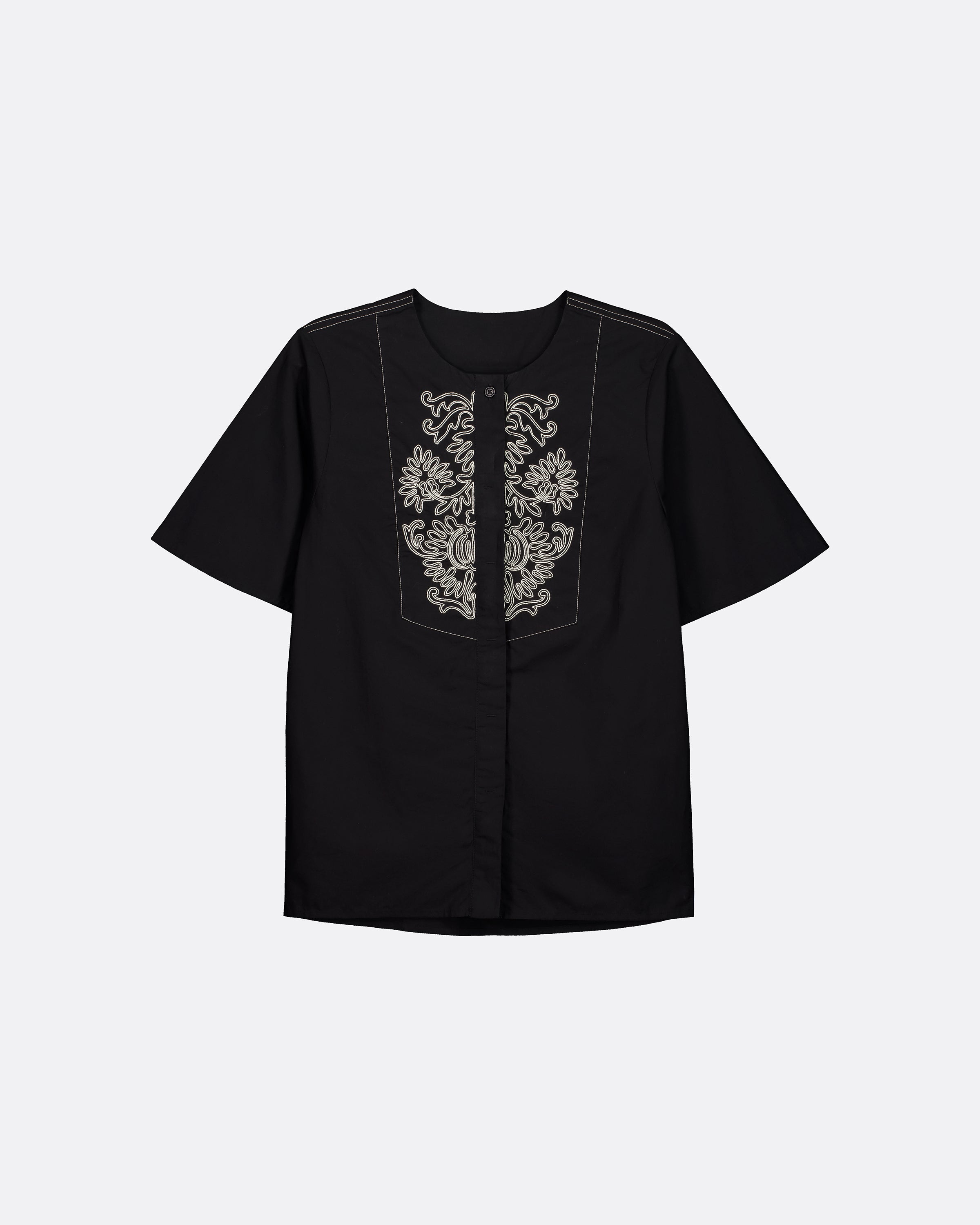 A black short-sleeve button-up shirt with ornate silver embroidery on the front chest panel, displayed against a light gray background.