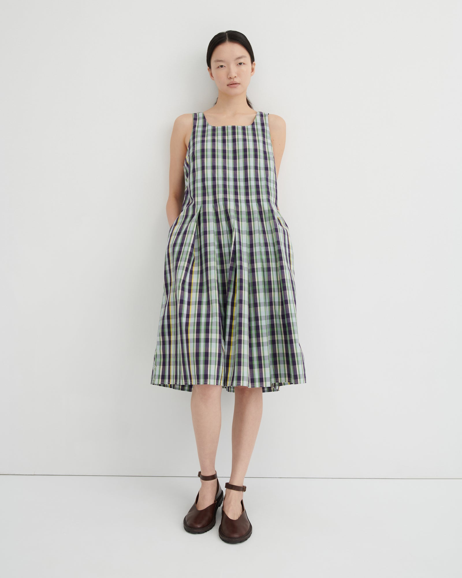 Woman wearing a plaid dress against a white background