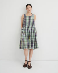 Woman wearing a plaid dress against a white background