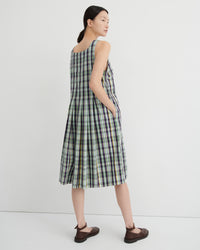 Woman wearing a green and white checkered dress against a white background