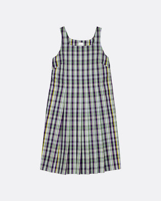 A sleeveless plaid pinafore dress with a white base and black, green, and yellow stripes, shown flat on a light gray background.