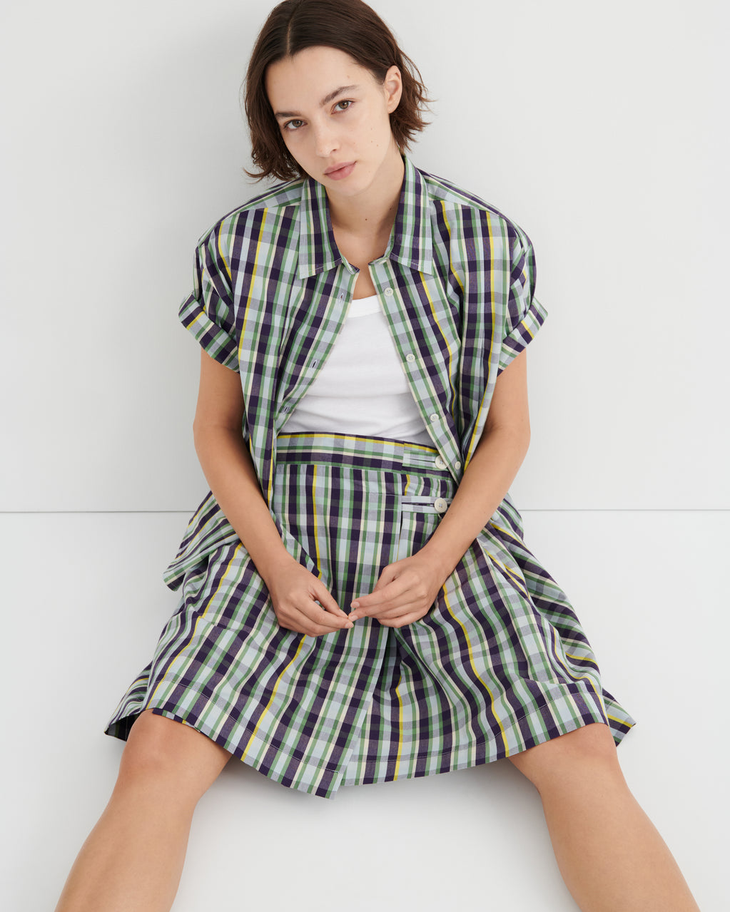 Woman wearing a plaid outfit with a white background