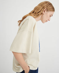 Woman wearing a beige oversized shirt on a white background