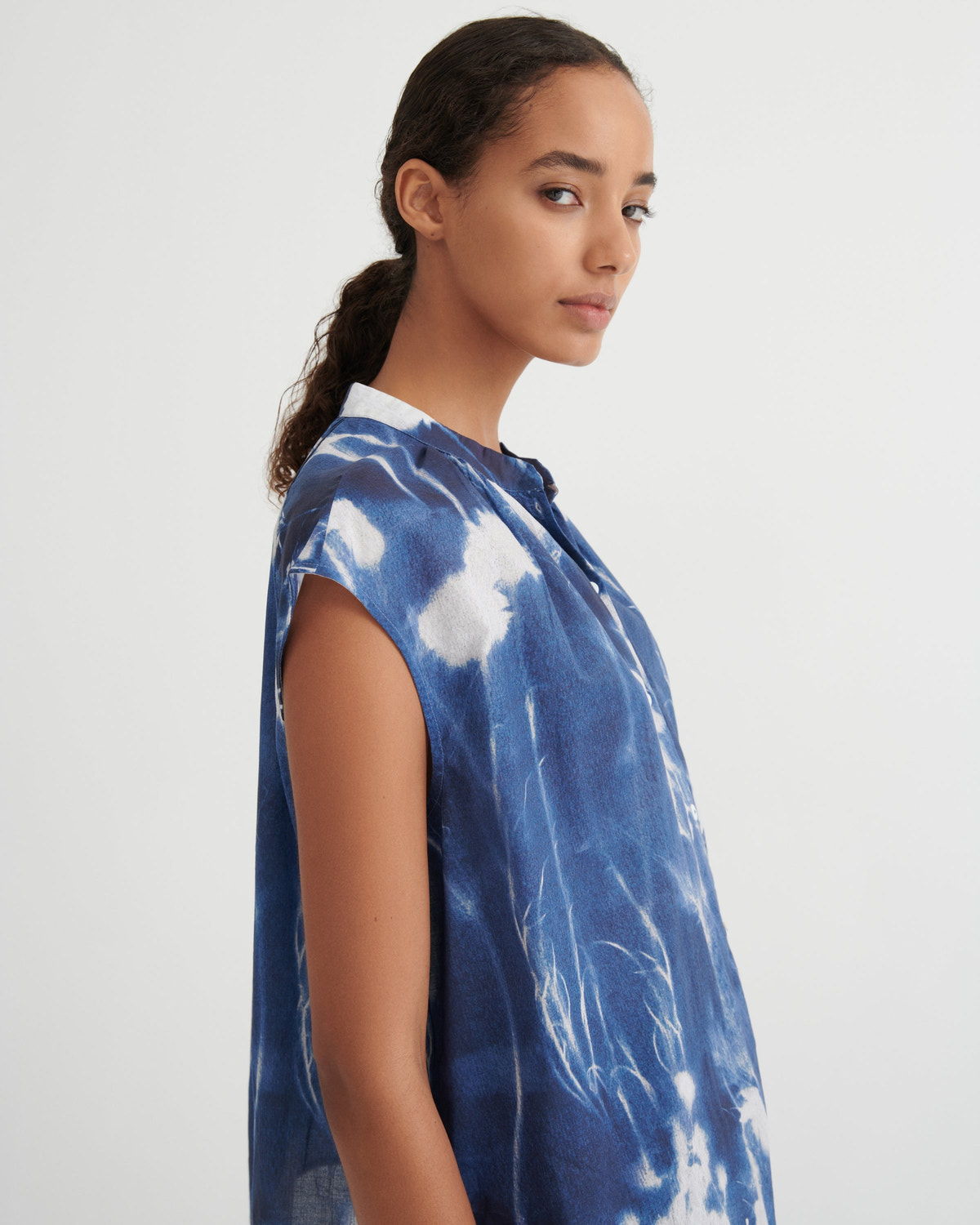 Woman wearing a blue tie-dye shirt on a white background