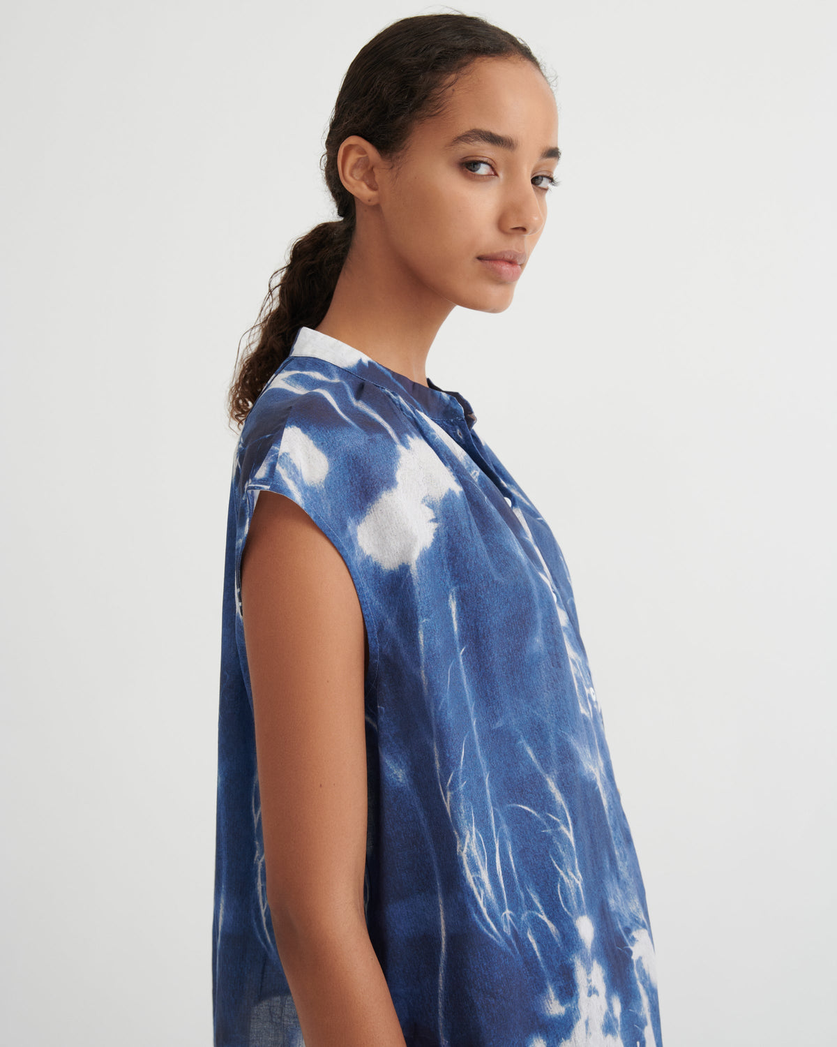 Woman wearing a blue tie-dye shirt on a white background