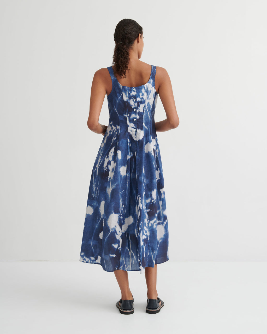 Woman wearing a blue floral dress on a white background