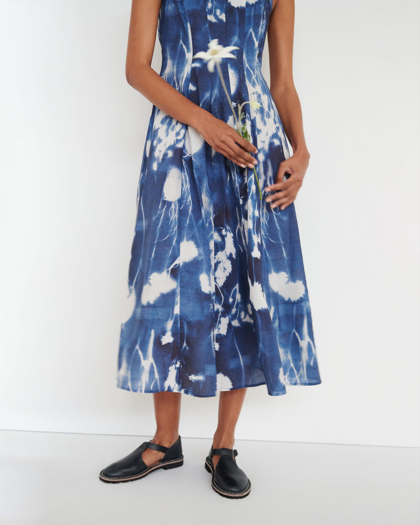 Woman wearing a blue and white floral dress on a white background