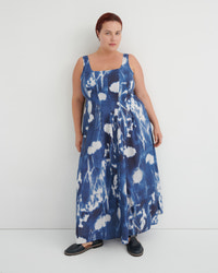Woman wearing a blue and white floral dress against a white background