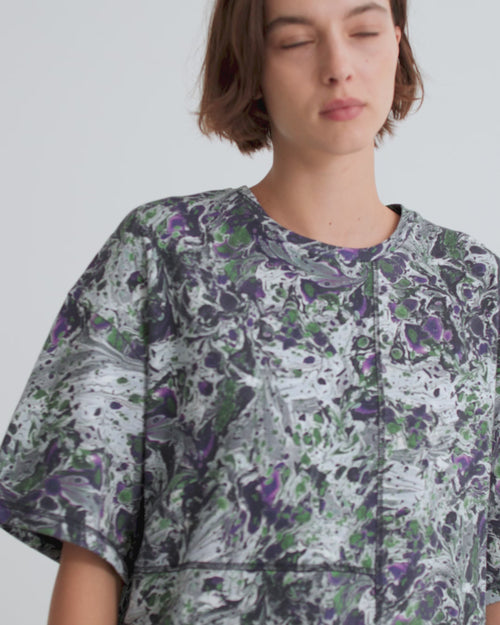 A women wearing a short sleeve top and maxi skirt in a marble print