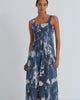 A women wearing a sleeveless dress in a blue cyanotype floral print with a fitted bodice.