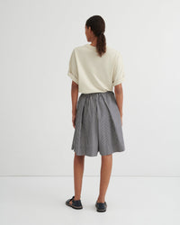 Person wearing a white top and striped skirt on a white background
