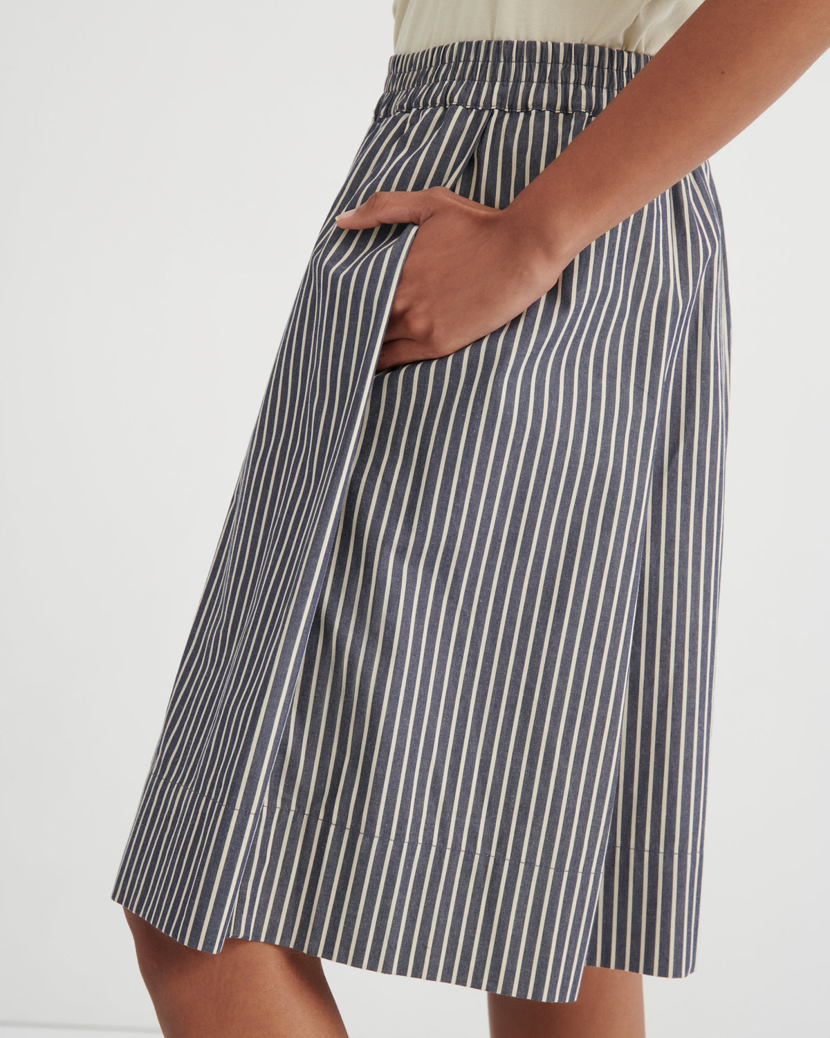 Person wearing a blue and white striped skirt on a white background